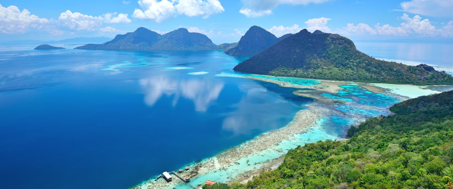 sipadan island aerial showing the volcanic cone and reef drop off